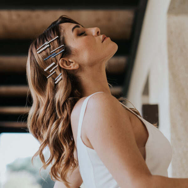 Coiffure de mariage, cheveux lachés, attachés avec une multitude de barettes perlées et de barettes en cristal bleu.