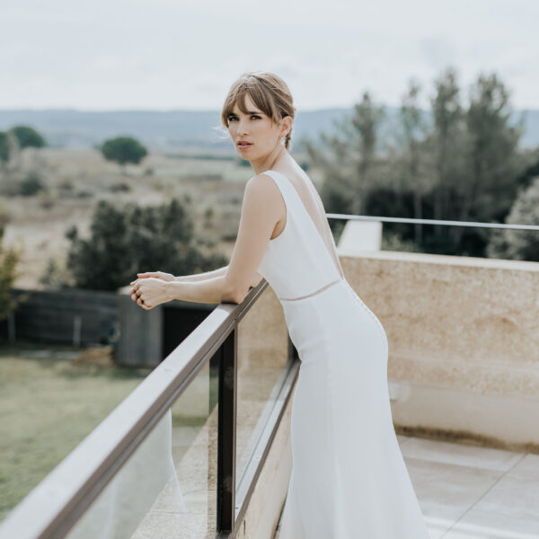 jeune mariée portant ses bijoux de mariage en perles d'eau douce et en porcelaine. Elle porte un collier pendant et des boucles d'oreilles.