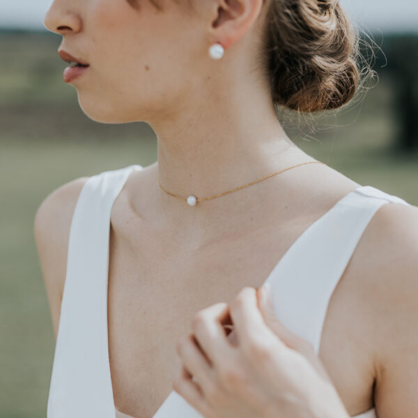 Bijoux de mariage simples et délicats portés par une mariée dans un paysage provençale.