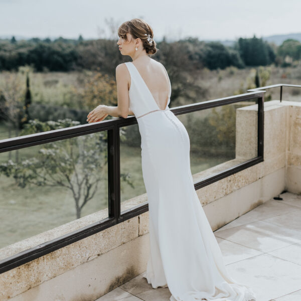 bijoux de mariage portés par une mariée accoudée à la ballustrade d'une villa provençale.