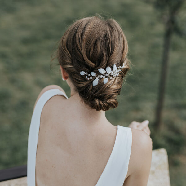 Coiffure de mariée habillée d'épingles à cheveux. Ces bijoux de mariage sont en perles d'eau douce et en porcelaine.