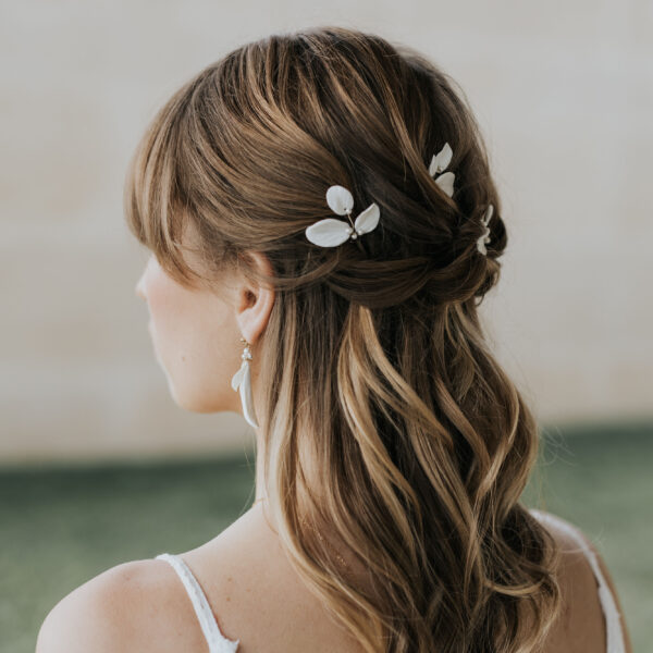 Coiffure de mariée élégante habillée d'épingles à chignon de mariage en porcelaine et perles de Swarovski.