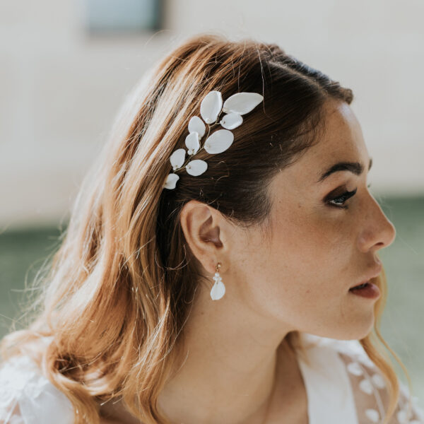 bijoux de mariage en porcelaine portés par une mariée. Elle porte une vigne de cheveux avec des feuilles en porcelaine rehaussées de perles, et des fines boucles d'oreilles.