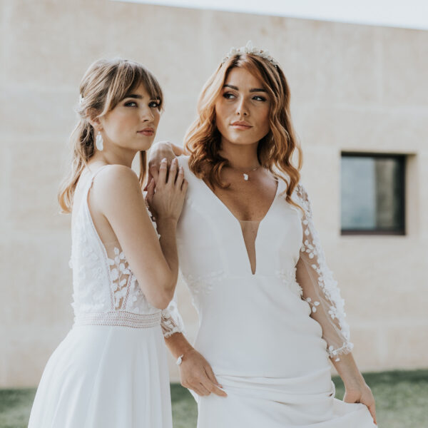 deux jeunes mariées portent leur bijoux de mariage en porcelaine avec leurs robes longues et décolletées.