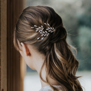 Accessoires cheveux de mariage en nacre et perles de Swarovski, portés par un mariée. Ces bijoux de mariage sont composés d'épingles à chignon.