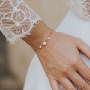 Bracelet de mariage fin et élégant en perles d'eau douce et porcelaine monté sur une fine chaîne.