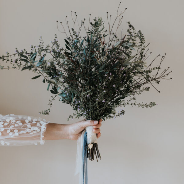 Bouquet de mariée, habillé à la poignée de rubans et d'un bijou de bouquet avec un médaillon photo.