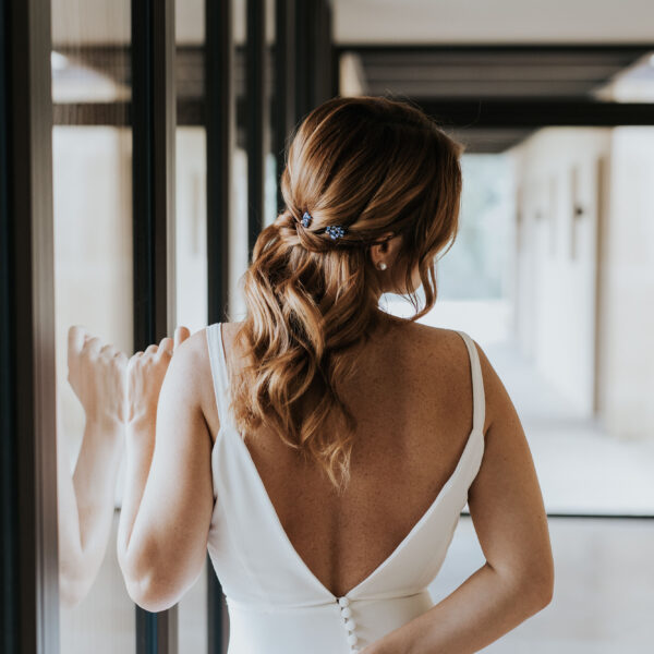 Mariée avec une coiffure de mariage détachée, avec des bijoux de cheveux discrets, bleu et strassé